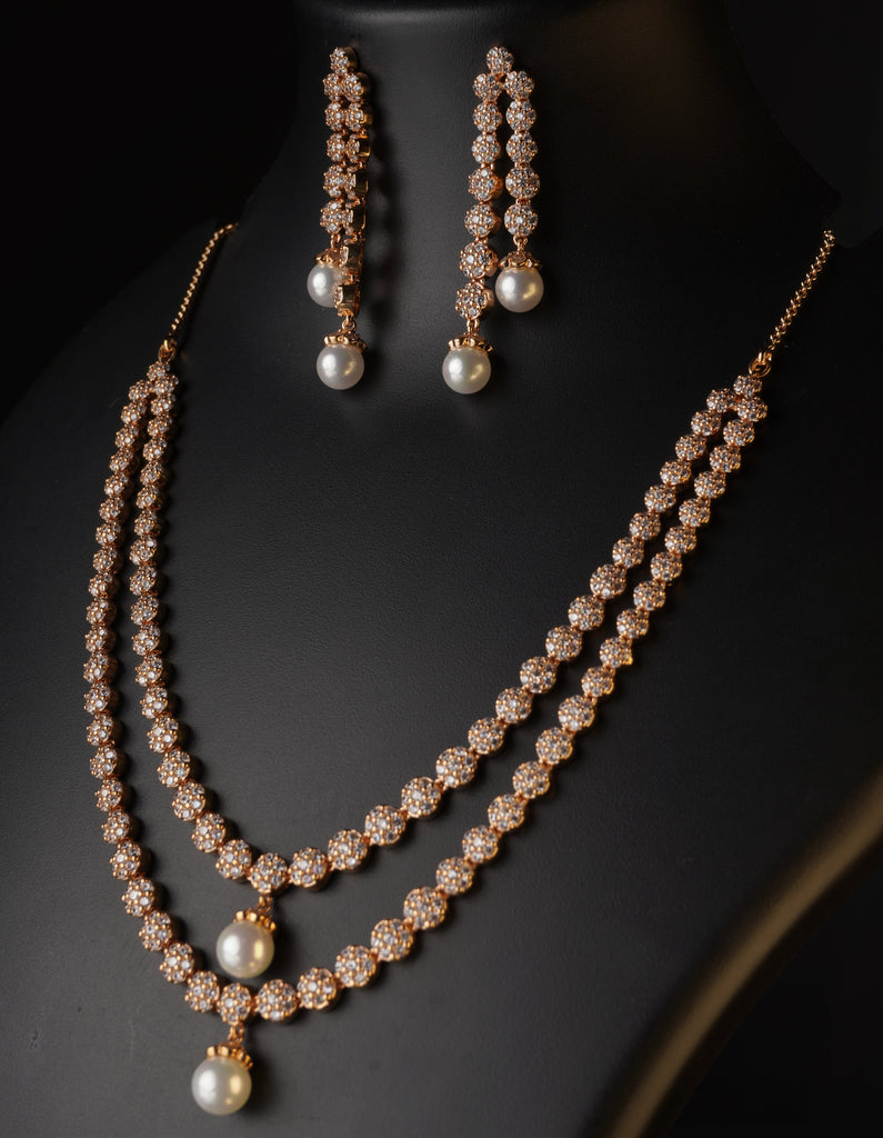 Pearl earring on a black stand against a dark green background