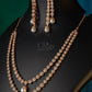 Pearl earring on a black stand against a dark green background